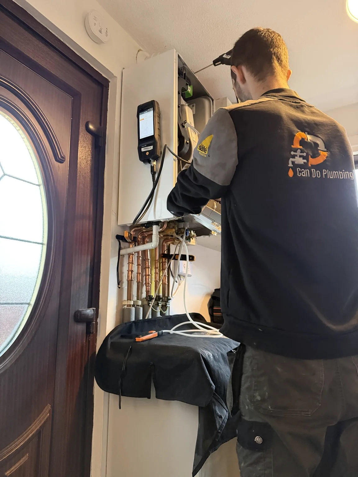 Can Do Plumbing engineer at work with testing equipment during boiler installation